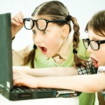 Cute boy and girl  looking at the laptop with surprise. Virtual learning.
