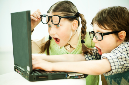 Cute boy and girl looking at the laptop with surprise. Virtual learning.