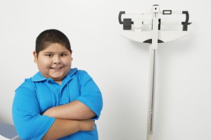 Childhood Obesity. Boy standing near scale.